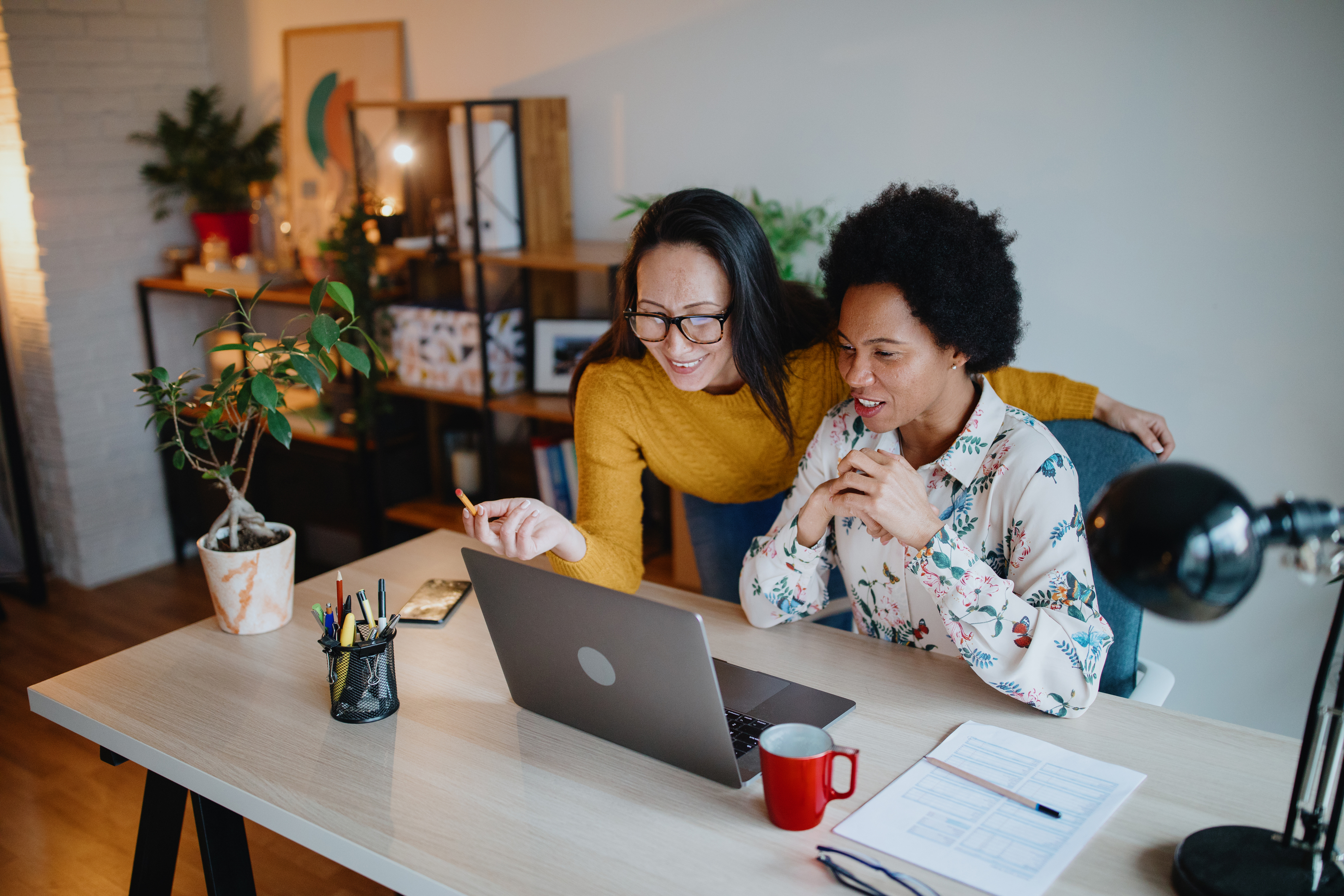 Two female business woman working in small shared office