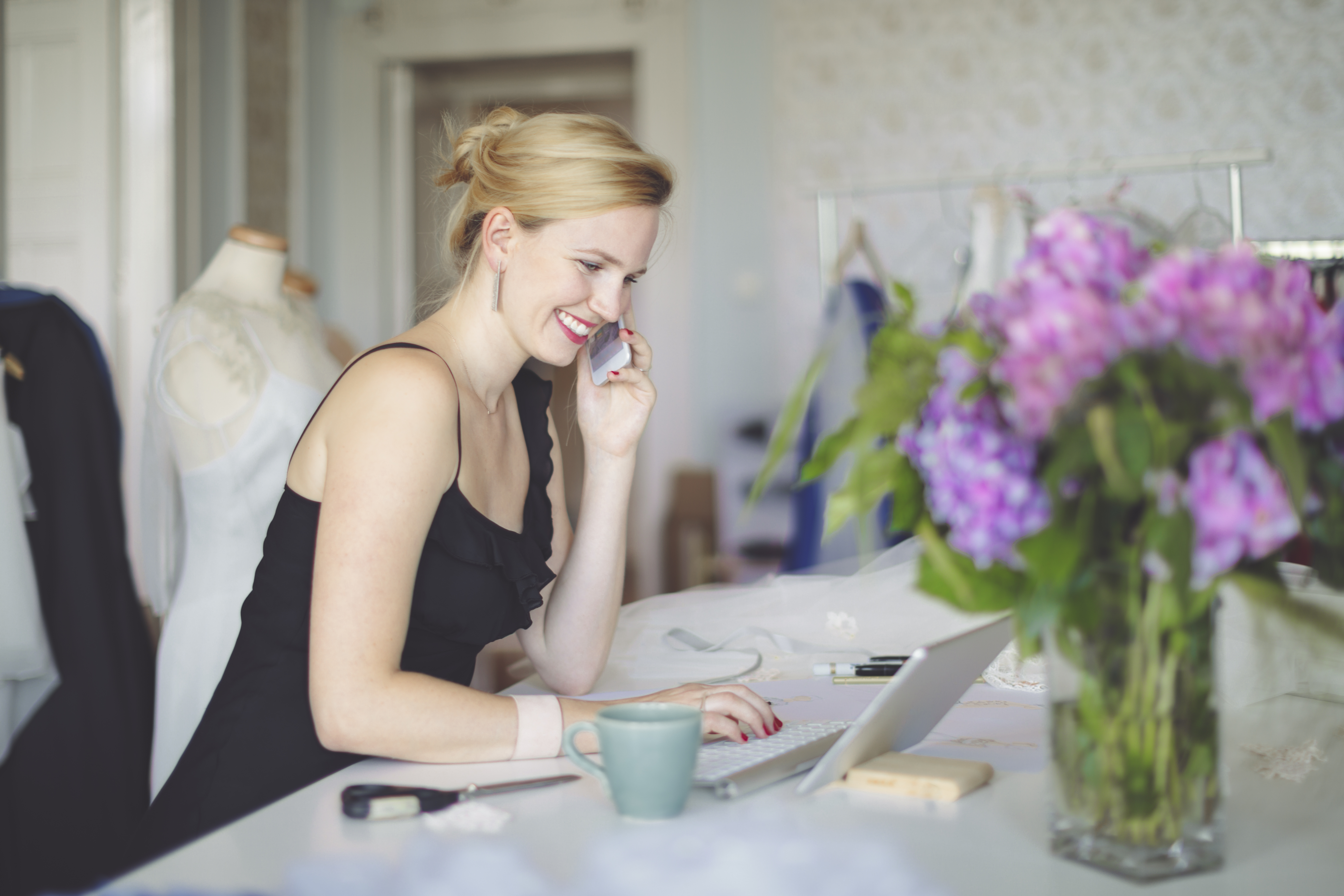 woman sitting a table talking on her cell phone