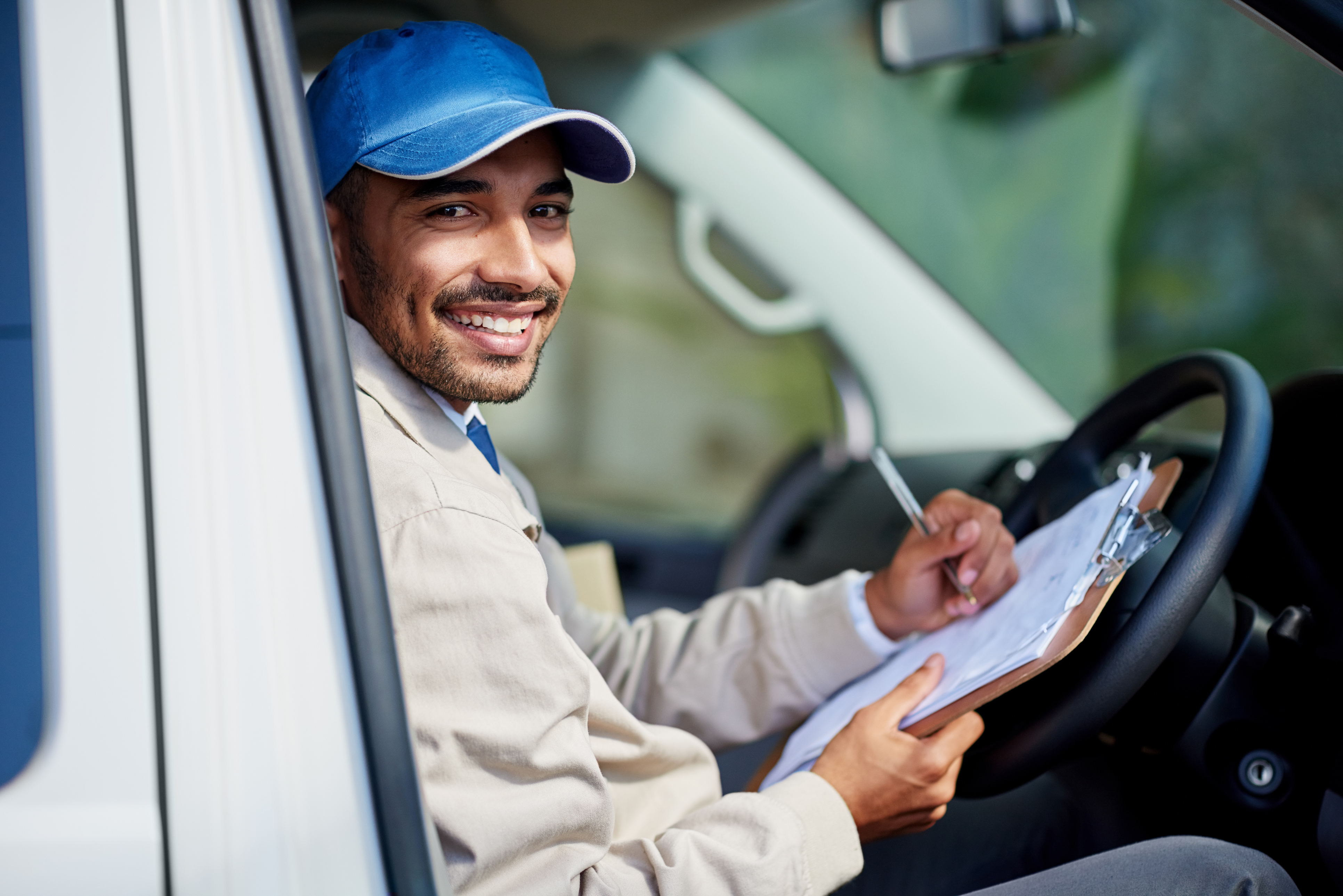 Portrait of a happy delivery man driving his van